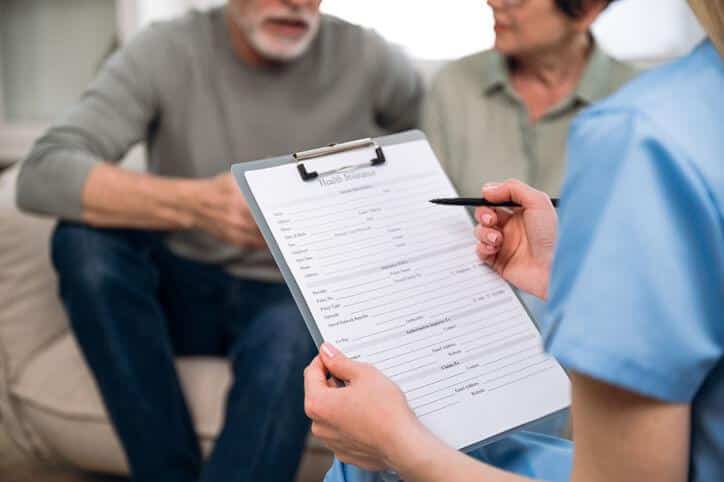 A clinical researcher collecting data from two respondents after clinical research training