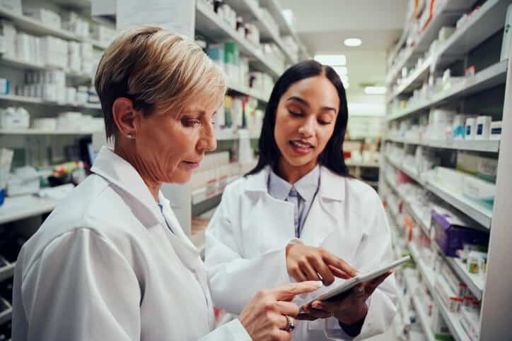 Female pharmaceutical school graduate interacting with a colleague.