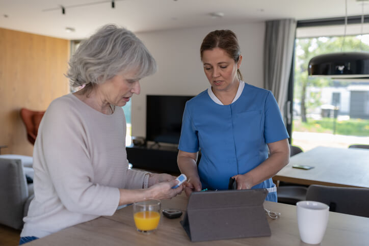 A Personal Support Worker Certificate graduate assisting an elderly patient with daily tasks