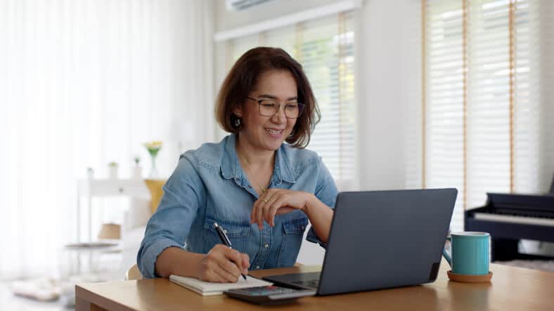 A female pharmaceutical industry professional attending a webinar at our pharmaceutical school and taking notes.