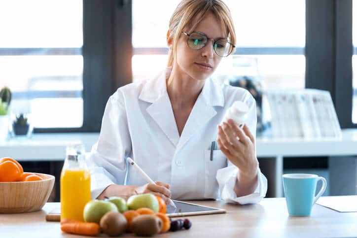 A female nutrition consultant prescribing a supplement after completing her Diploma in Nutrition